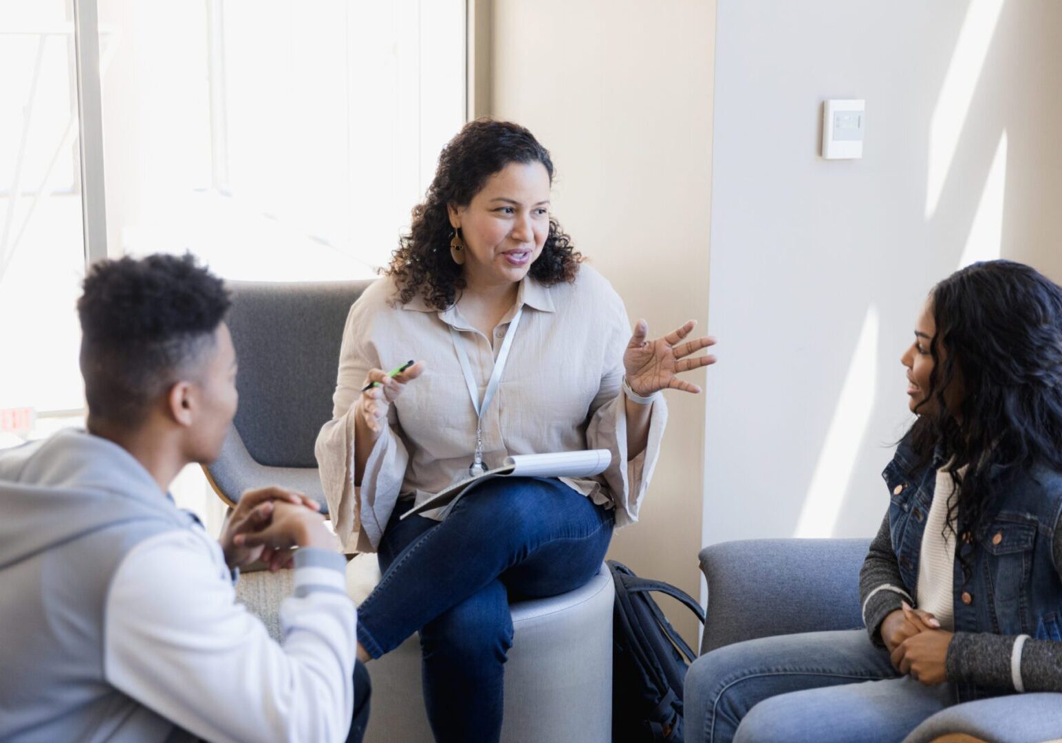 The professor has a small group meeting with the students to help them with their project.
